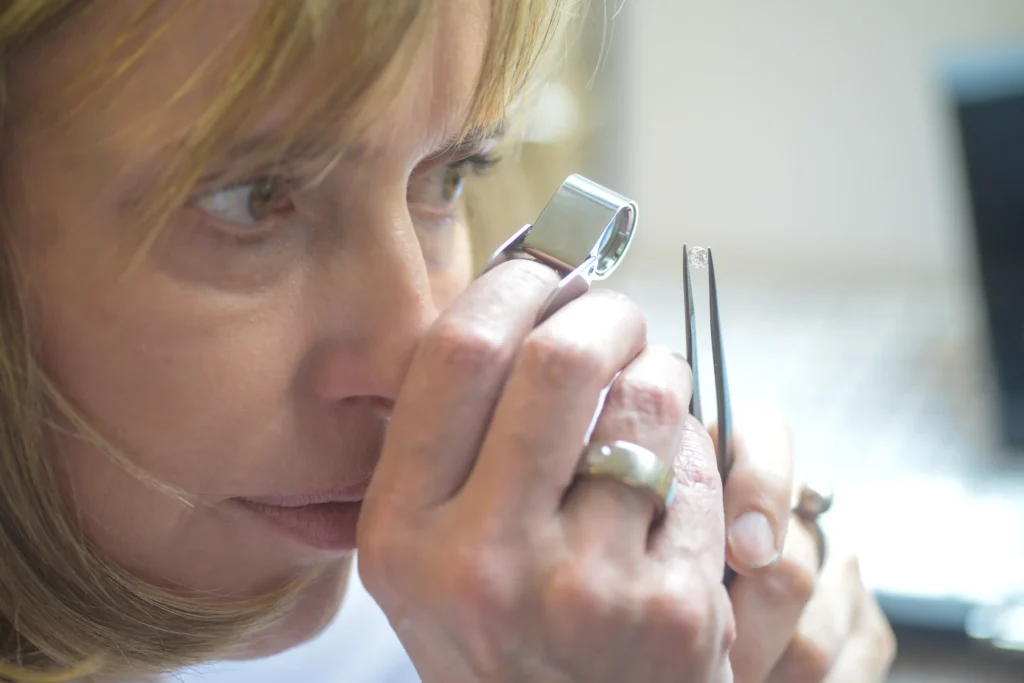 Präzise Handwerkskunst: Inge Lagerpusch prüft einen Diamanten aufmerksam durch eine Juwelierlupe.