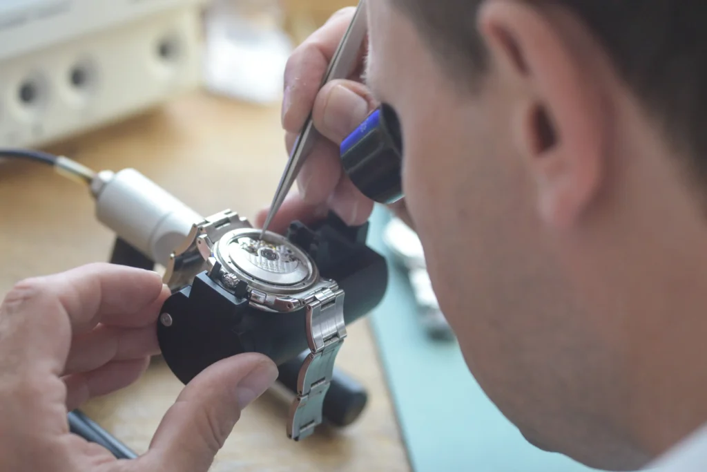 Makroaufnahme eines filigranen mechanischen Uhrwerks während der präzisen Feinregulierung (Reglage) in unserer hauseigenen Uhrmacherwerkstatt.